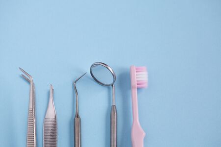 Dental tool with mirror, toothbrush on blue backgroundの写真素材