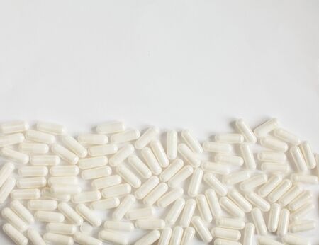 White capsules on a white background. Half of the background is filled with pills. Coronovirus text phrase on white.の写真素材