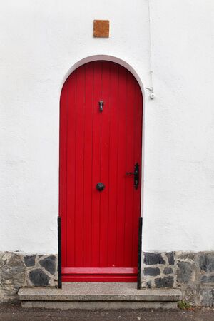 Old red door in a white wallの写真素材