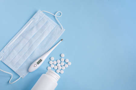 Thermometer, protective mask and pills on blue backgroundの写真素材