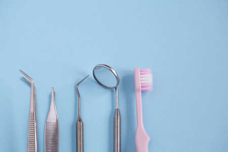 Dental tool with mirror, toothbrush on blue backgroundの写真素材