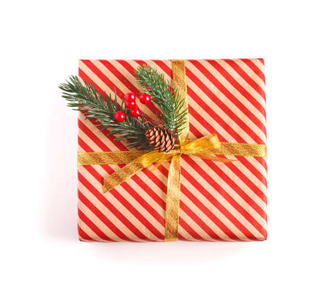 Decorated christmas box with spruce sprigs and golden ribbon isolated on whiteの写真素材