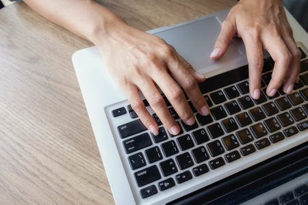 businesswoman use on-line via laptop computer for analyzing financial chart,writing business plan,open net-book,smart watch,tablets,with copy space screen,morning light,vintage colorの写真素材