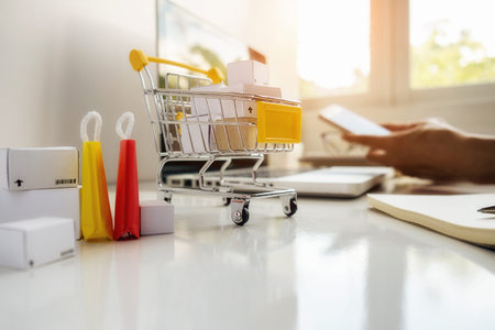 Internet online shopping concept with smartphone and shopping-cart.Vintage tone retro filter effect,soft focus(selective focus)の写真素材