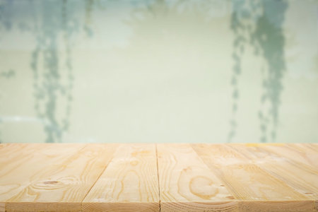Empty wooden table platform with over blurred silhouettes on the curtains background for...