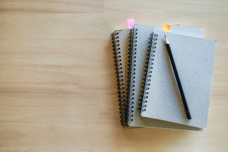 Office desk table with notebook and Pencil on Wooden Backgroundの写真素材