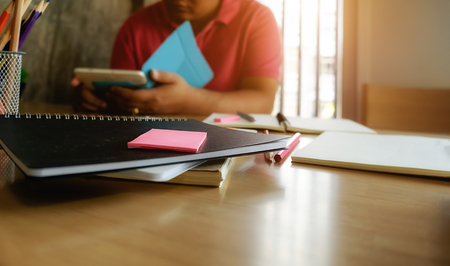 Side view of business man working at office with smartphone and documents on his desk at his office while looking serious consultant,morning light,vintage color,selective focus. Business concept.の写真素材