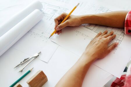 Hands of Engineer working on blueprint,Construction concept. Engineering tools.Vintage tone retro filter effect,soft focus(selective focus)の写真素材
