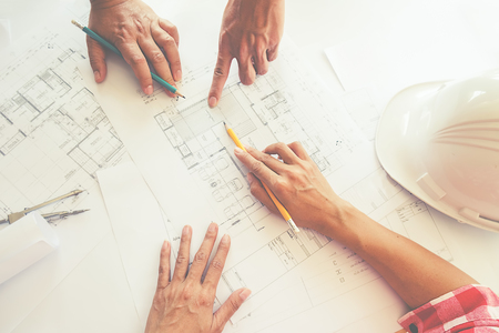 Hands of Engineer working on blueprint,Construction concept. Engineering tools. Vintage tone.の写真素材