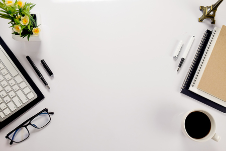 Office desk table with keyboard, notebook, pen, cup of coffee and flower. Top view with copy space (selective focus)

の写真素材