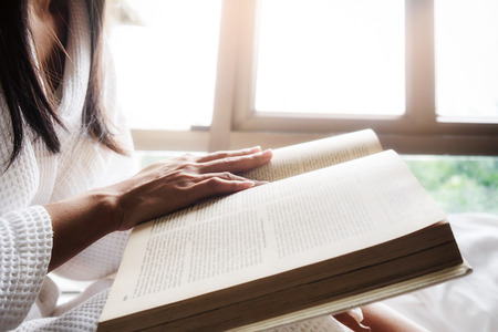 Reading a book.Beautiful female sitting on the bed and reading a book.Morning with a book. Relaxing concept. Retro filter effect,soft focus,selective focus.

の写真素材
