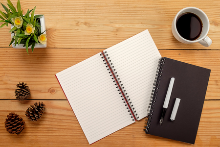 Office desk table with pen  cup of coffee and flower. Top view with copy spaceの写真素材