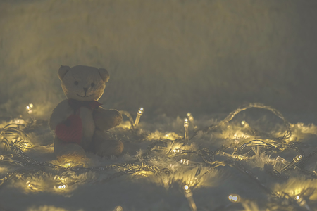 Cute teddy bear on wool Background with bokeh .Soft focus,low light.(selective focus).の写真素材