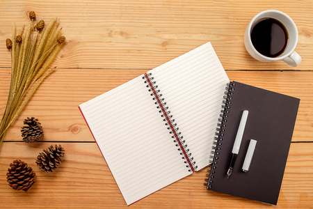 Office desk table with pen  cup of coffee and flower. Top view with copy spaceの写真素材
