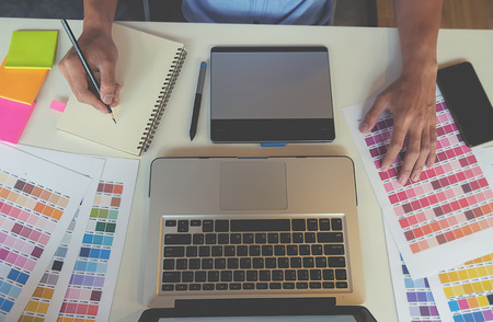 Graphic design and coloured swatches and pens on a deskの写真素材
