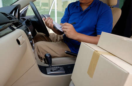 Delivery driver driving with parcels on seatの写真素材