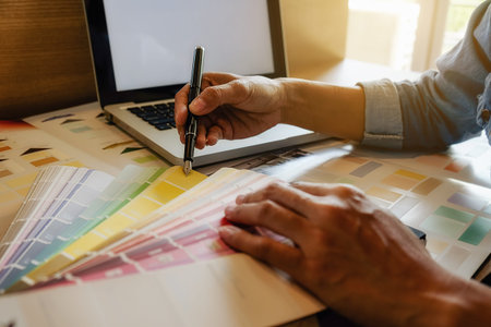 Graphic design and color swatches and pens on a desk. Architectural drawing with work tools and...
