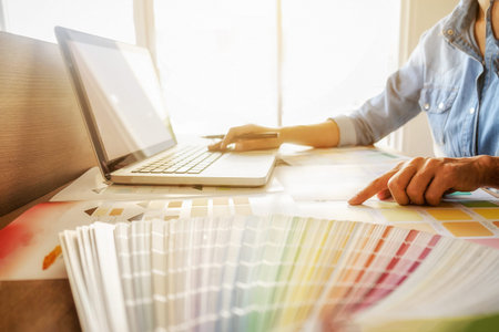 Graphic design and color swatches and pens on a desk. Architectural drawing with work tools and...