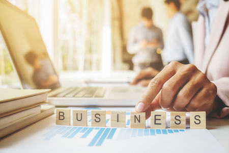 Business concept. Hand put the last piece of crossword to complete the mission (selective focus).の写真素材