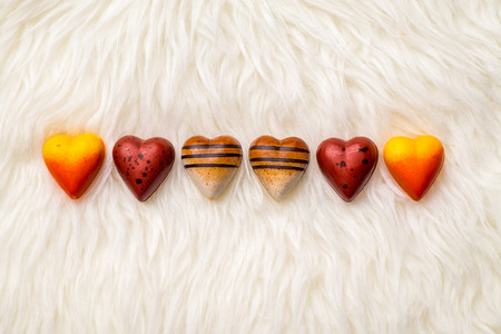 Valentine theme: Heart-shaped chocolate on fur texture.の写真素材