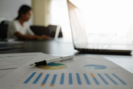 Business woman use on-line via laptop computer for analyzing financial chart,writing business...
