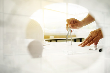 Close up of Engineer sketching a construction project at work place.vintage tone.の写真素材