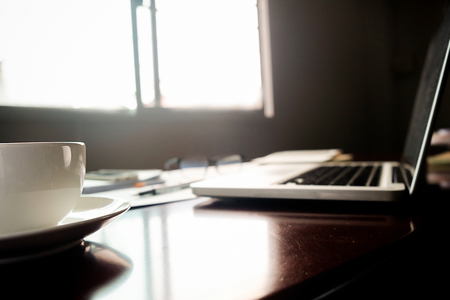 Business concept with copy space. Office desk table with pen focus and analysis chart, computer, notebook, cup of coffee on desk.Vintage tone Retro filter, selective focus.の写真素材
