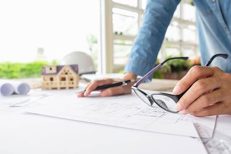 Hands of Engineer working on blueprint,Construction concept. Engineering tools.Vintage tone retro filter effect,soft focus(selective focus)の写真素材