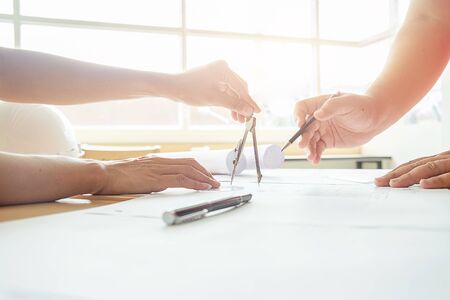 Image of engineer meeting for architectural project, working with partner and engineering tools on workplace vintage tone. Construction concept.selective focusの写真素材