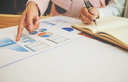 Business concept. Business people discussing the charts and graphs showing the results of their...