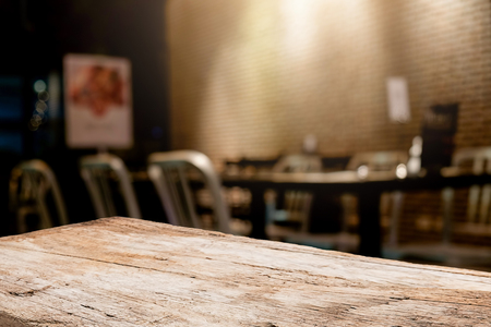 Empty wooden table space platform and blurred coffee shop where working and meeting place background for product display montage.の写真素材