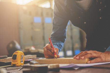 Carpenter working on woodworking machines in carpentry shop. woman works in a carpentry shop.の写真素材