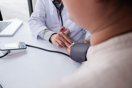 Patient listening intently to a male doctor explaining patient symptoms or asking a question as they...
