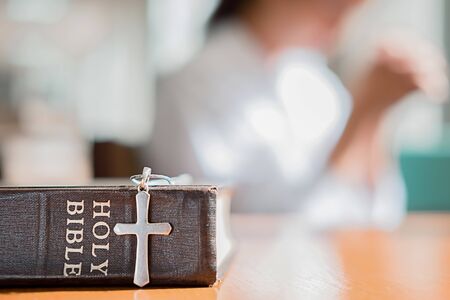 Christian woman praying on holy bible. Hands folded in prayer a holy bible in church conceptの写真素材