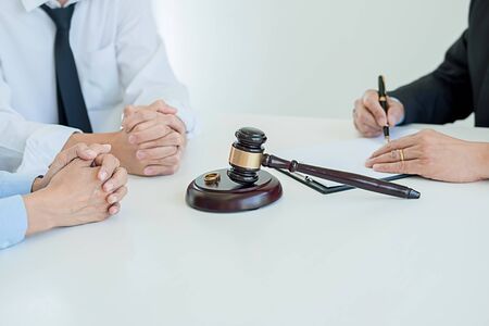 Judge gavel with Justice lawyers deciding, consultation on marriage divorce between married couple and signing divorce documents on table. Concepts of Law and Legal sevices.の写真素材