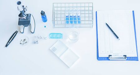 Medical or scientific researcher or man doctor looking at a test tube of clear solution in a laboratoryの写真素材