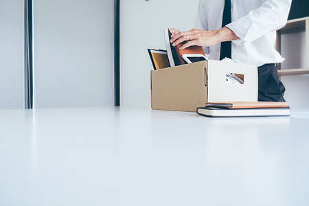 Sad dismissed businessman sitting outside the office after losing his jobの写真素材