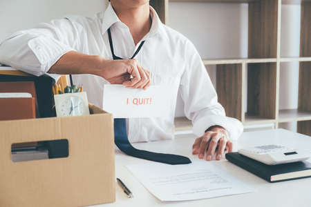 Sad dismissed businessman sitting outside the office after losing his jobの写真素材