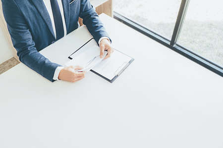 Sad dismissed businessman sitting outside the office after losing his jobの写真素材