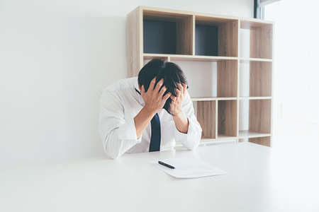 Sad dismissed businessman sitting outside the office after losing his jobの写真素材