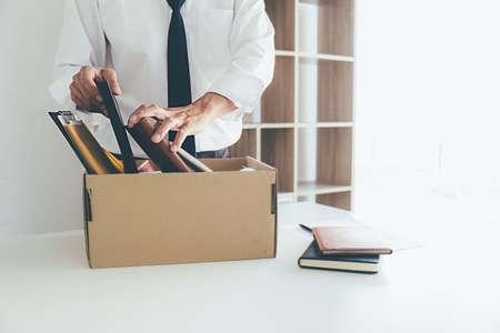 Sad dismissed businessman sitting outside the office after losing his jobの写真素材