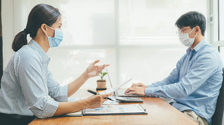Asian People Successful Teamwork Business Wearing Medical Mask and Working. Work from Private Office Social Distancing among Coronavirus Outbreak Situationの写真素材