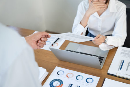 Business people discussing the charts and graphs showing the results of their successful teamworkの写真素材