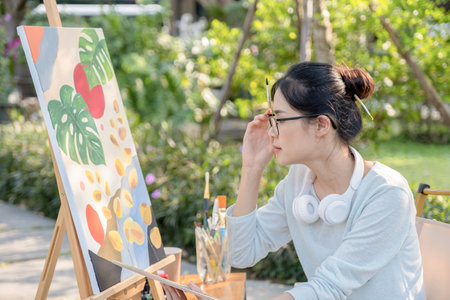 asian woman painting on easel in the garden, art conceptの写真素材