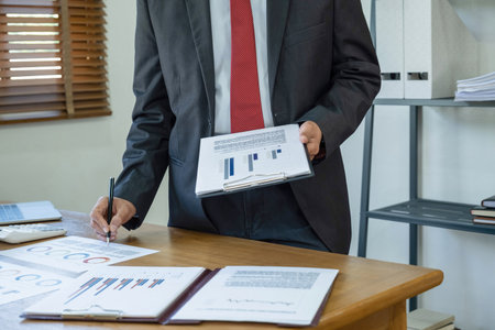 Businessman analyzing investment charts with laptop in office. Accounting concept.の写真素材