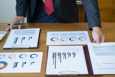 Businessman analyzing investment charts with laptop and calculator. Accounting concept.の写真素材