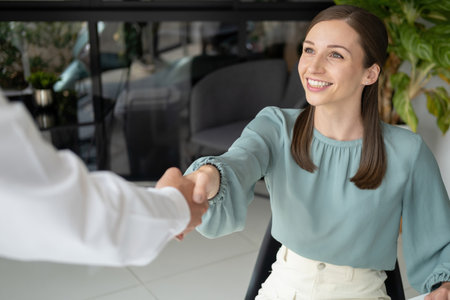 Businessman and businesswoman, coworker in office at workplace working together and shaking hands on agreement and completed work. Businesspeople happy to work with each other. Working, business, partnership concept.の写真素材