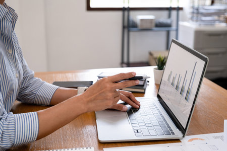 Close up of businesswoman working on laptop computer at office desk. Business and finance concept.の写真素材