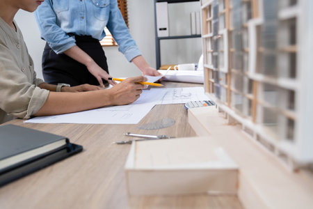 Architect or engineer working on blueprint at office desk, architectural concept.の写真素材