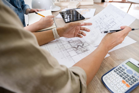 Architect or engineer working on blueprint at office desk, Construction concept.の写真素材